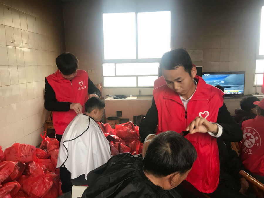 (图为志愿者为老人贴心理发)