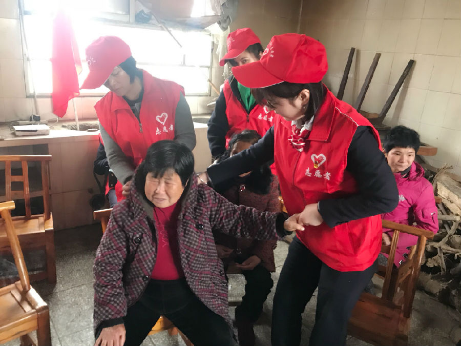 (图为志愿者为老人用心按摩)