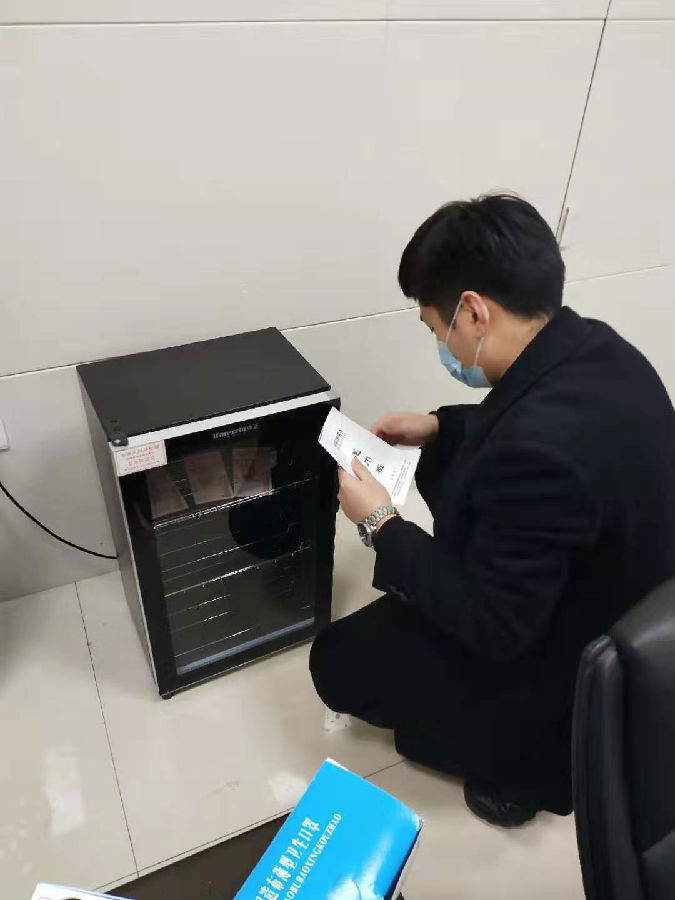 丹阳支行工作人员用消毒柜给现金消毒.jpg