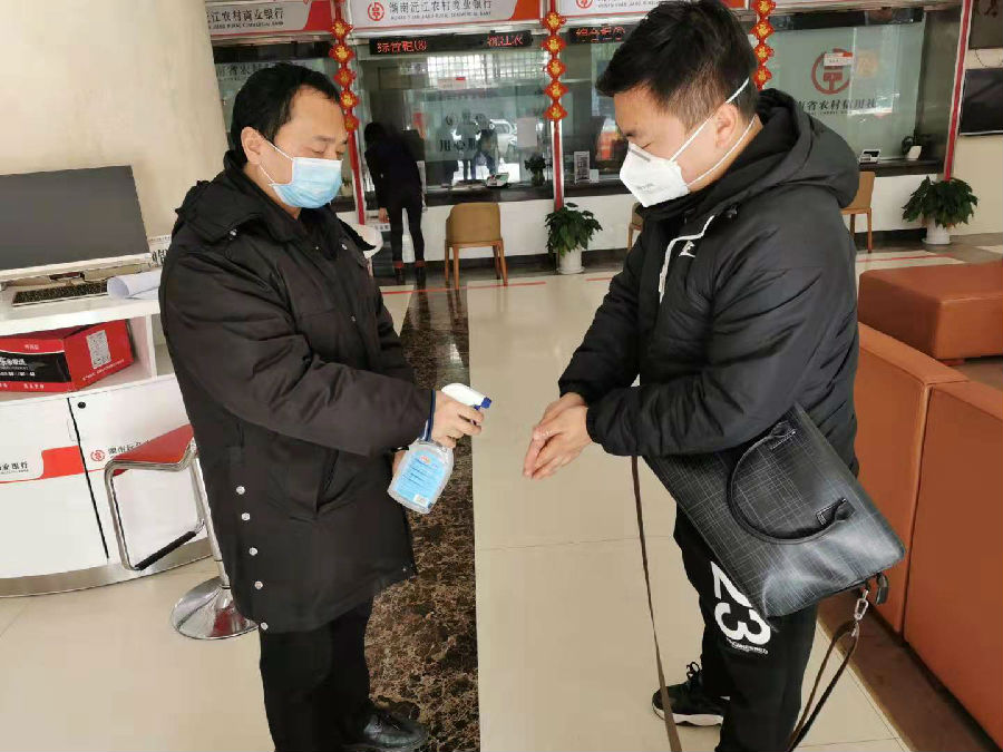 沅江农商银行员工为客户消毒.jpg