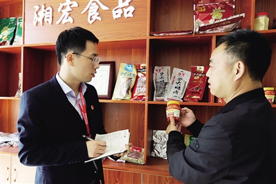 2 在湖南湘宏食品股份有限公司,负责人向衡山农商银行的工作人员介绍公司产品。.jpg