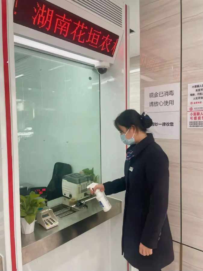 图为营业部对现金柜台进行消毒.jpg